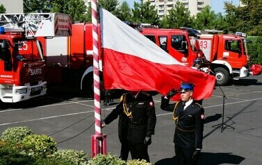 Przejście na emeryturę st. bryg. Leszka Zielińskiego (zdjęcie przedstawia strażak&oacute;w wciągających flagę Polski na maszt)