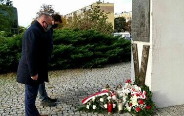 Wciąż żywi w naszej pamięci (na zdjęciu znajduje się mężczyzna składajacy kwiaty)